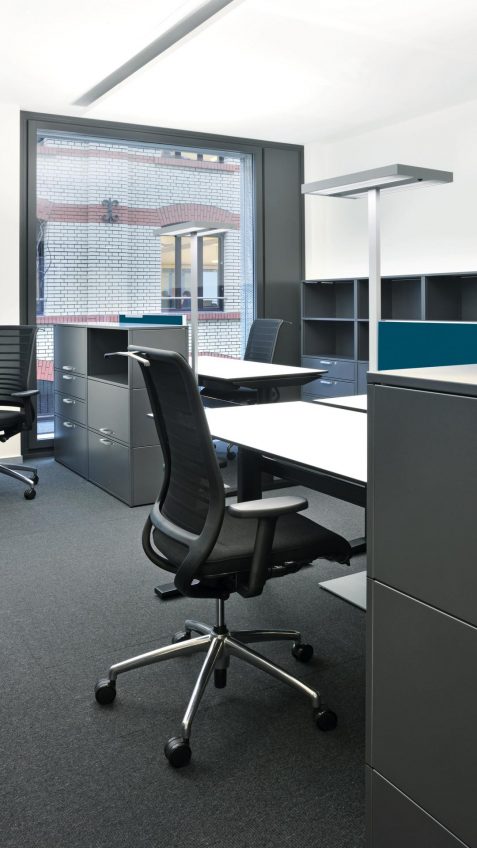 Schwarzer Bürostuhl Sanitas Hero im modernen Büro Schwarzer Bürostuhl Sanitas Hero im modernen Büro