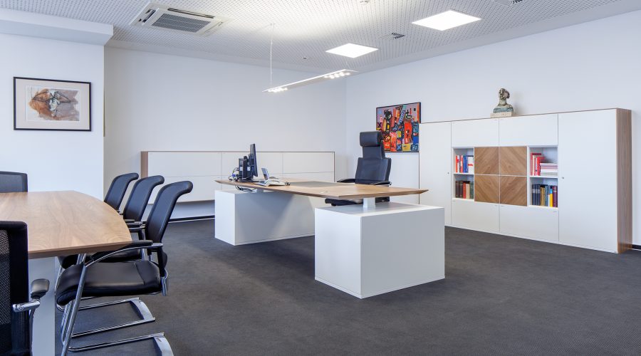 Hochwertige Chefbüro Einrichtung mit großem Schreibtisch und Konferenztisch Chefbüro mit Holzschreibtisch, Konferenztisch und Stauraum – hochwertige Einrichtung für Führungskräfte.