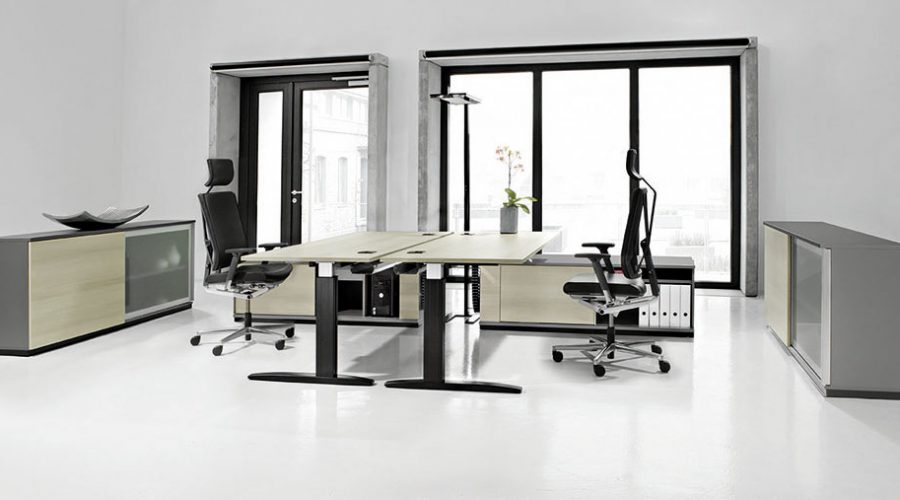 Ergonomischer Arbeitsplatz mit höhenverstellbarem Schreibtisch und moderner Bürogestaltung